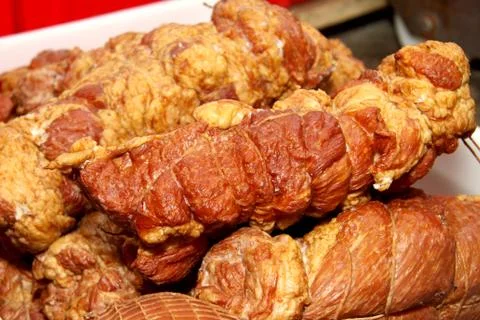 A worker at the meat processing factory, prepares sausages at the work table Stock Photos
