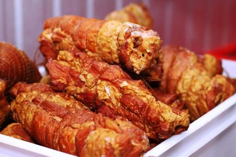 A worker at the meat processing factory, prepares sausages at the work table Stock Photos