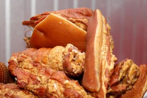 A worker at the meat processing factory, prepares sausages at the work table Stock Photos