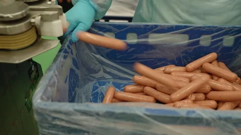 Worker at a meat processing plant producing sausages. Stockbeeldmateriaal 267546932