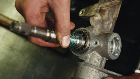 Worker mechanic apply dense grease lubricant to a steering rack and repair Stock Footage 284545117