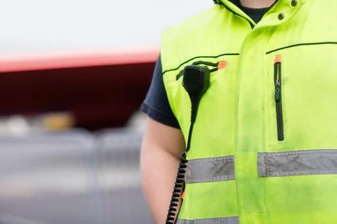 Worker With Microphone Attached On Reflective Jacket At Airport Stock Photos