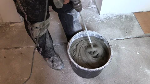 Worker mix adhesive cement for tile on bucket with tool Stock Footage 42255195