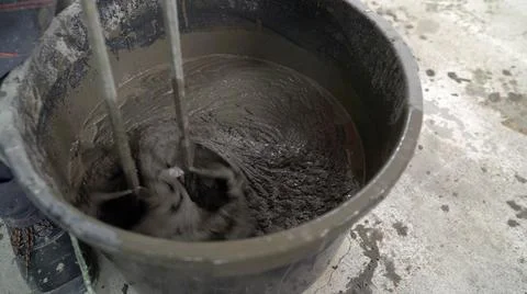 A worker mixes the solution in a bucket. A man mixes a solution with water in a Stock Photos