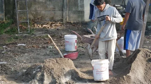 A worker is mixing cement and sand using pure water Stock Footage 157136528