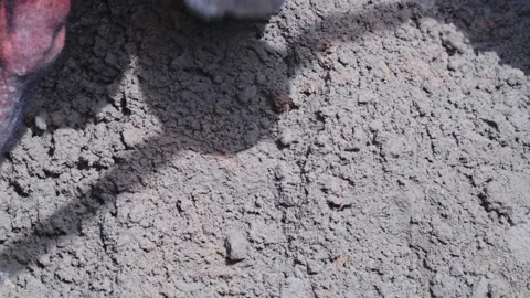 Worker mixing cement and sand using hoe tool for plastering work at Stock Footage 331231287