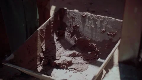 Worker mixing cement and sand plaster at a rustic construction site in Stock Footage 343852552