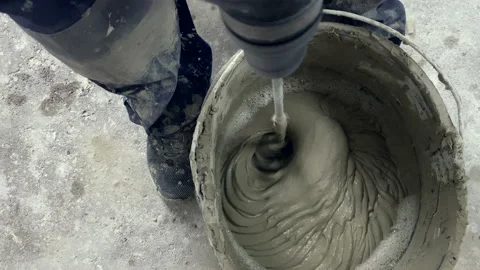 Worker mixing cement in the bucket in construction site Stock Footage 153678173
