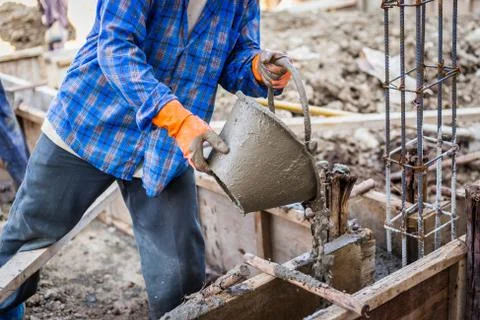 Worker mixing cement mortar plaster for construction Stock Photos
