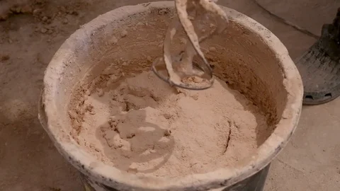 Worker mixing gypsum plaster with special long drill Stock Footage 130026832
