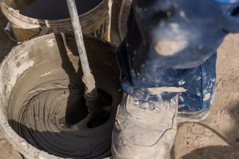 Worker mixing plaster with a drill in a bucket. Stock Photos