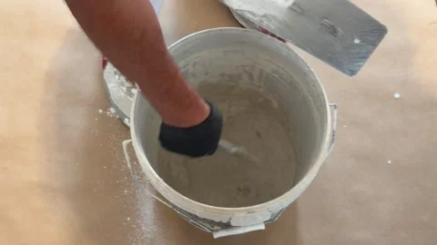 Worker mixing plaster putty in a bucket Vídeo Stock 341362963