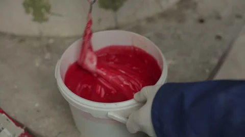 Worker mixing red liquid to combine with silicone Stock Footage 58638945