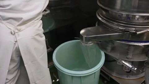 Worker Mixing Starch and Water Beside a Sifting Machine Stock Footage 340009429