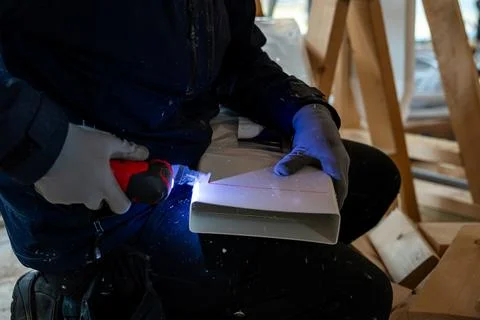 Worker Modifying Ventilation Duct in Indoor Construction Site Stock Photos