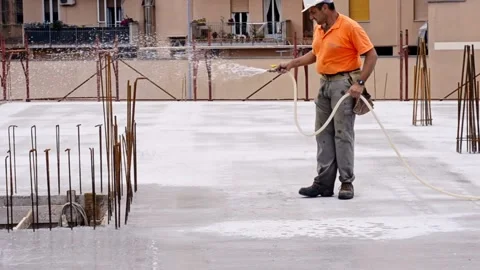 Worker moistens the surface of the concrete used for the construction of a fl Vídeo Stock 171854278