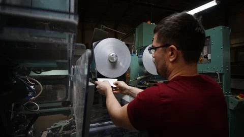 The worker mount a foil rolls for cigarettes packing 스톡 사진