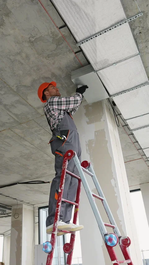 Worker mounts ceiling ventilation system in office Stock Footage 314570159