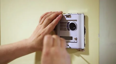Worker mounts cover on external part of home intercom Stock Footage 51875545