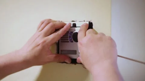 Worker mounts external part of home intercom into mounting box. Stock Footage 51876388