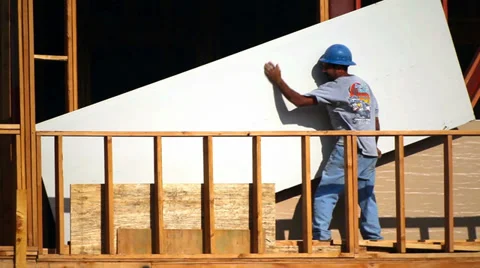 Worker moves a drywall to the higher floor at construction site Video stock 34576245