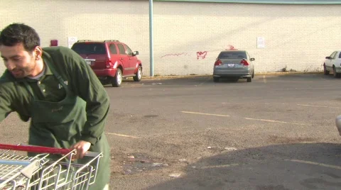 Worker moves shopping carts Stock Footage 479693