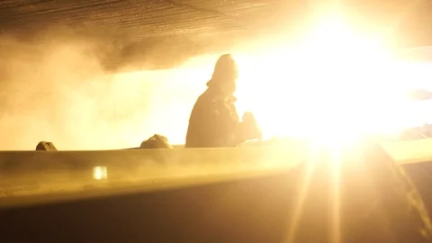 Worker moving coal ashes from the conveyor belt at an electricity plant with Stock Footage 121811091