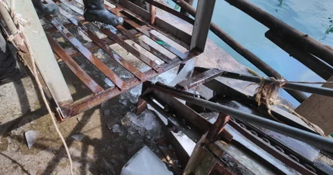 Worker moving large blocks of ice from a cart into an ice crusher Stock Footage 327440397