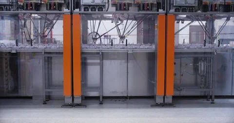 Worker moving trays of chocolate in front of chocolate manufacturing machines Stock Footage 104001112