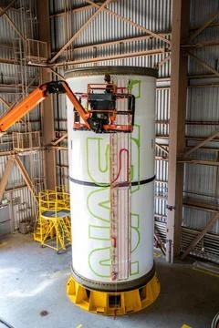 A worker with NASAs Exploration Ground Systems (EGS) applies bright red p.. Fotos de archivo