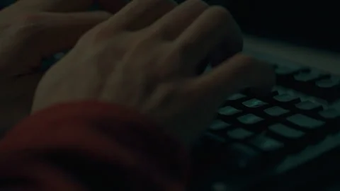 A worker at night is concentrated writing code on a portable laptop, his han Stock Footage 255682987