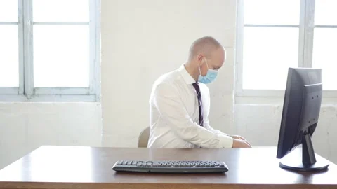 Worker in office putting face mask then handling hand written cardboard english Stock Footage 143373318