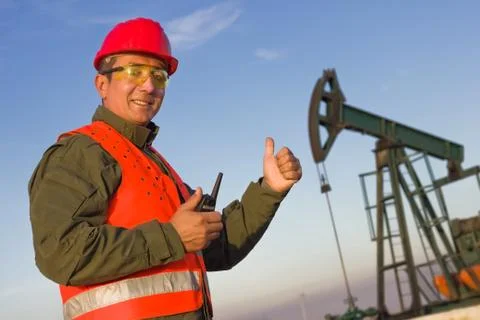 Worker on an oil rig elevated thumbs Stock Photos