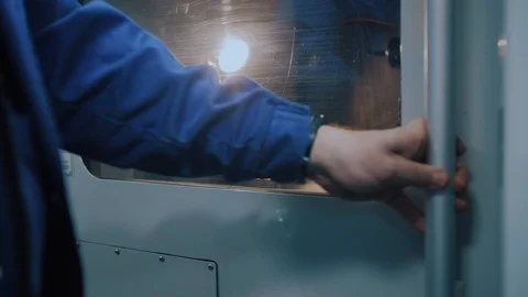Worker open the door of cnc machine at workshop. Video stock 104981160