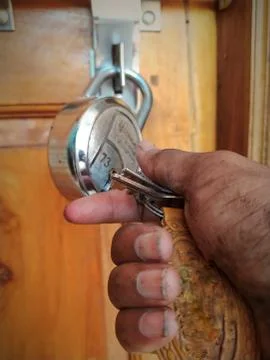 Worker open unlock the door lock with holding in key in dirty hand Stock Photos