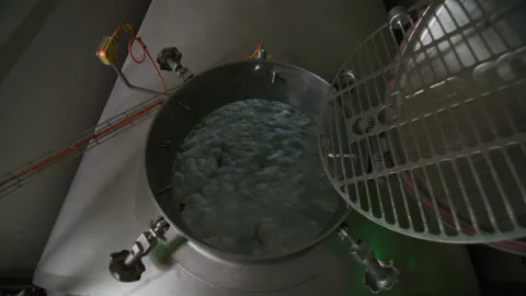 Worker opens hatch in metal tank with chemicals at plant Stock-Footage 255297177
