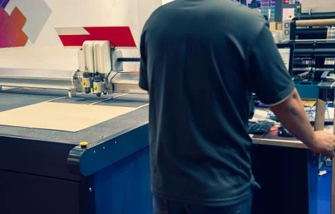 Worker operate digital cutting machine Stock Photos