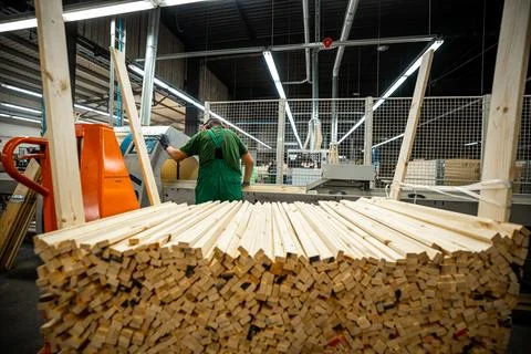 A worker operates a computerized machine in a woodworking factory, processi.. Stock Photos