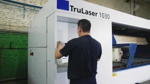 Worker operates with control panel of laser cutting machine Stock Footage 137022519