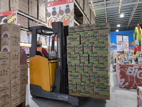 Worker operates forklift in bustling warehouse Stock Photos