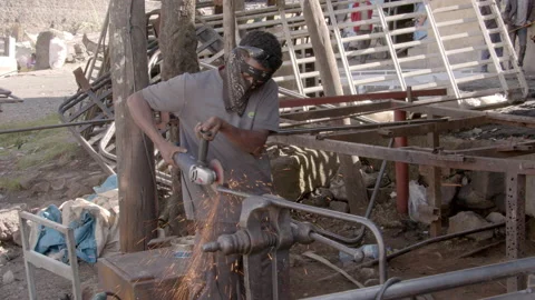 A worker operates a grinder in Ethiopia Stock Footage 221442748