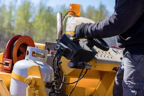 Worker operates machinery in construction site d move materials on job Stock Photos