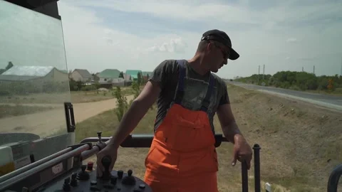A worker operates the milling machine control panel while driving Stock Footage 145466053