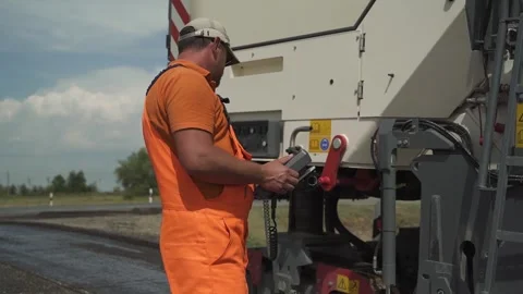 A worker operates the milling machine control panel while driving Stock Footage 145466063
