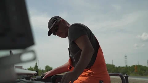 A worker operates the milling machine control panel while driving Stock Footage 145466065