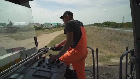 A worker operates the milling machine control panel while driving Stock-Footage 145466069