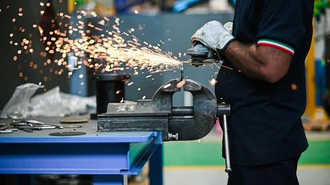 Worker operating an angle grinder and making lots of sparks, closeup shot Stock Photos