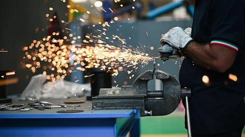 Worker operating an angle grinder and making lots of sparks, closeup shot Stock Photos