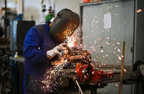 Worker operating an angle grinder and making lots of sparks Stock Photos