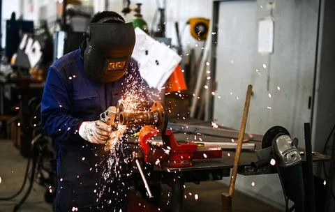 Worker operating an angle grinder and making lots of sparks Stock Photos